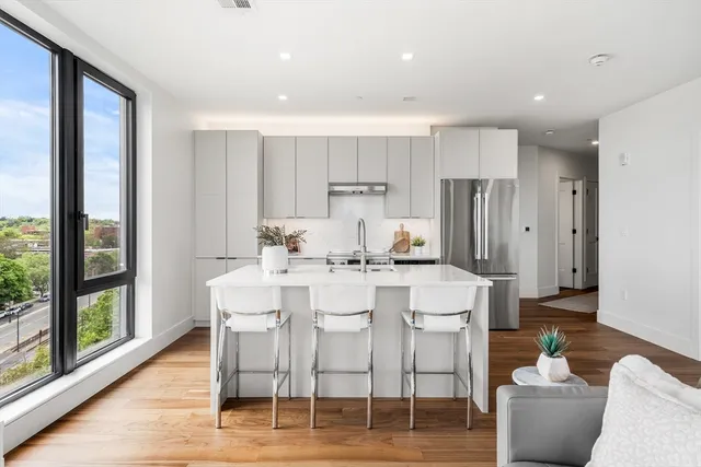 a kitchen with stainless steel appliances kitchen island granite countertop a dining table and chairs