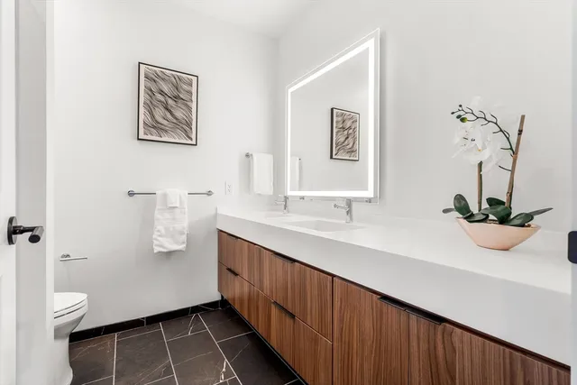 a bathroom with a sink a toilet and a mirror