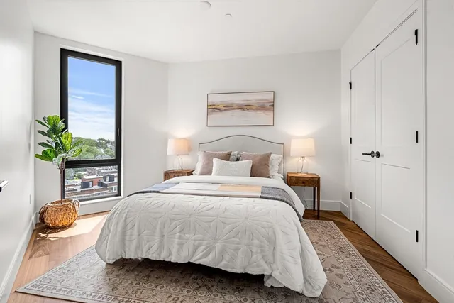 a bedroom with a bed and a potted plant