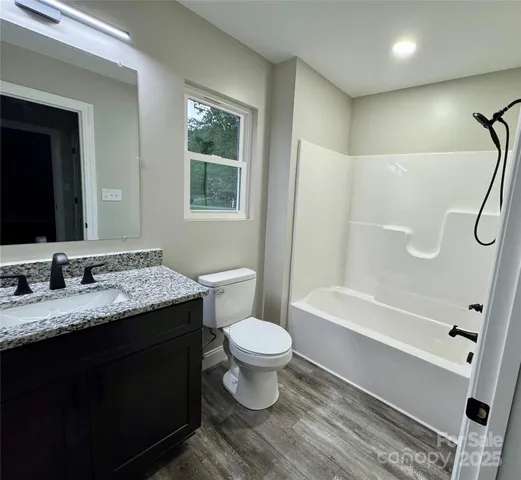 a bathroom with a granite countertop toilet sink and mirror