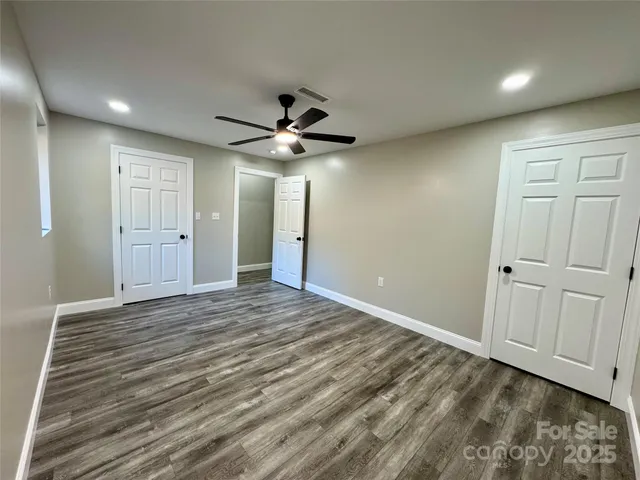 en empty room with wooden floor and ceiling fan