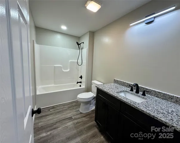 a bathroom with a granite countertop sink toilet a bathtub and shower