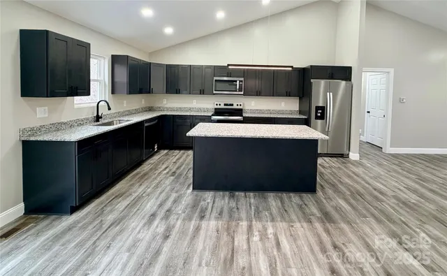 a kitchen with stainless steel appliances a refrigerator sink and wooden cabinets