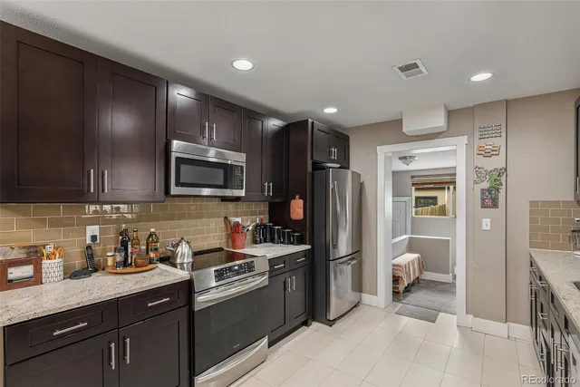 a kitchen with stainless steel appliances granite countertop a refrigerator and a sink
