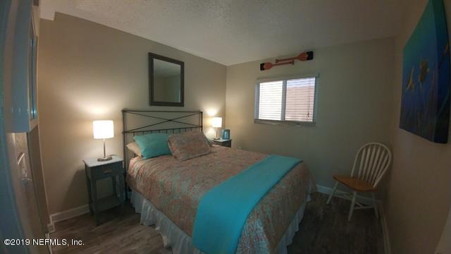 4 Ocean Trace Road, Unit 108 St. Augustine, FL 32080 - Photo 11 of 21 a bedroom with a bed and a chair with the potted plant