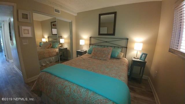 4 Ocean Trace Road, Unit 108 St. Augustine, FL 32080 - Photo 12 of 21 a bedroom with a bed and a mirror