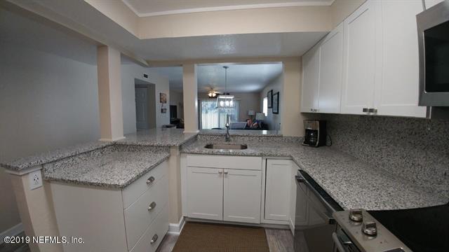 4 Ocean Trace Road, Unit 108 St. Augustine, FL 32080 - Photo 6 of 21 a kitchen with granite countertop a sink and cabinets