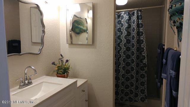 4 Ocean Trace Road, Unit 108 St. Augustine, FL 32080 - Photo 9 of 21 a bathroom with a sink and mirror with bathtub