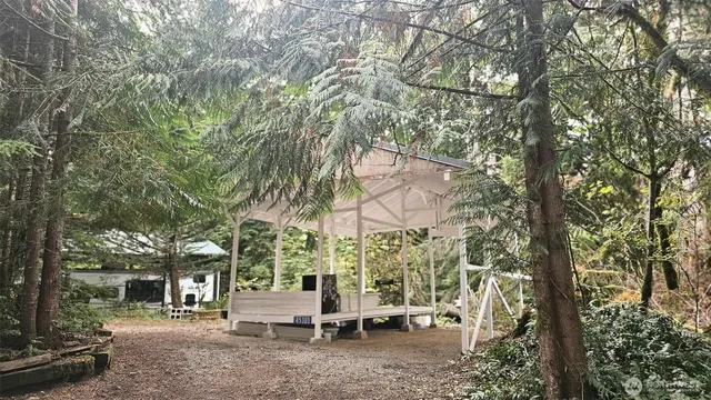 a view of patio with chairs and tables with large trees
