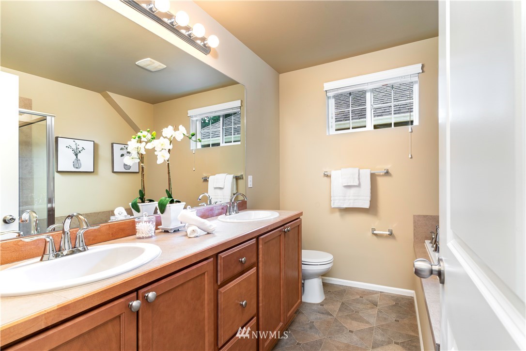 3801 219th Place Southeast Bothell, WA 98021 - Photo 14 of 22 a spacious bathroom with a double vanity sink a large mirror a toilet and a shower
