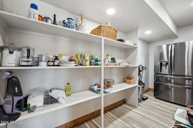 a kitchen with a refrigerator and wooden floor