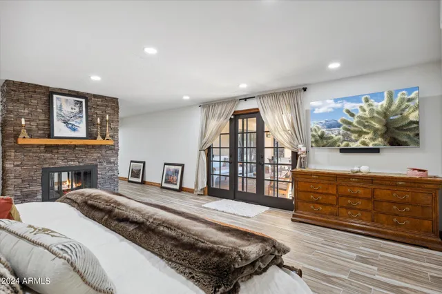 a spacious bedroom with a large bed and a flat tv screen