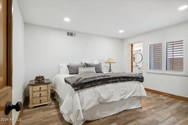 a bedroom with a bed and wooden floor
