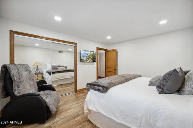 a spacious bedroom with a bed and wooden floor