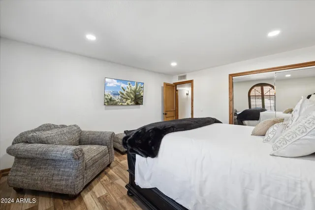 a spacious bedroom with a bed a couch and a window