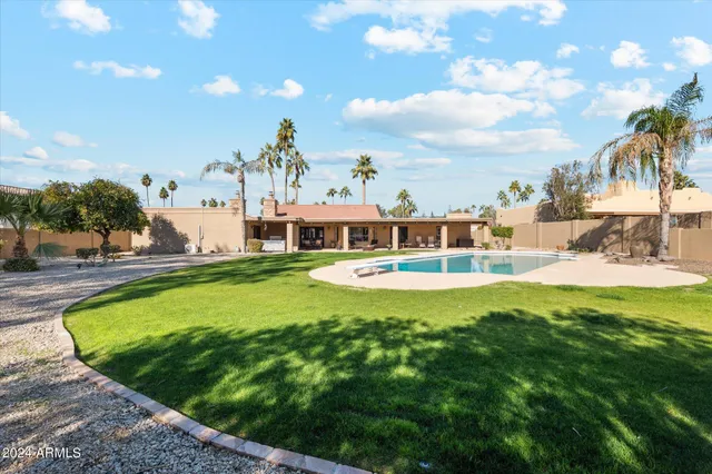 a view of a house with swimming pool and a yard