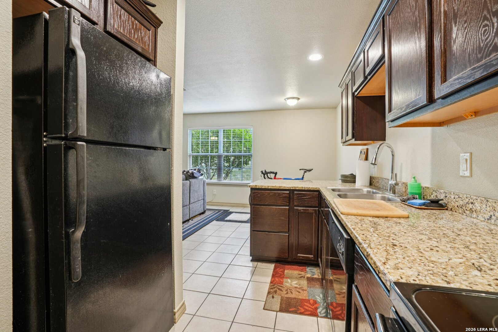 2312 Sailing Way, Unit A Kerrville, TX 78028 - Photo 12 of 29 a kitchen with stainless steel appliances granite countertop a refrigerator a sink and wooden cabinets