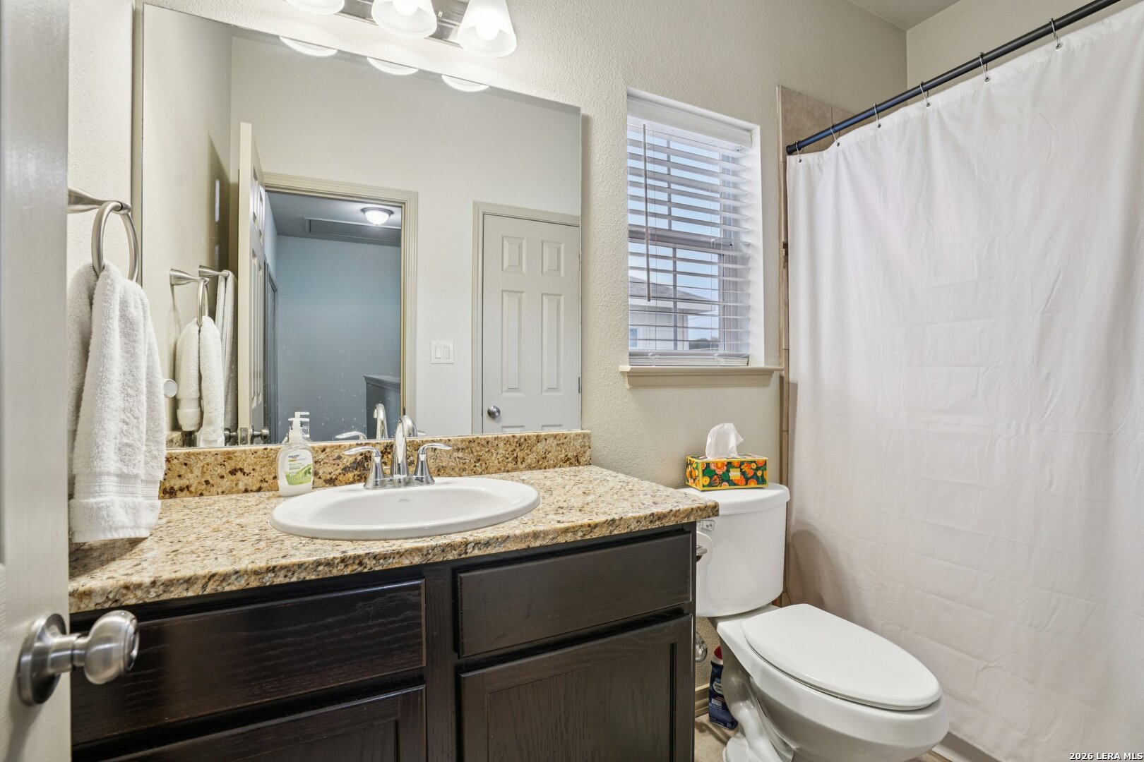 2312 Sailing Way, Unit A Kerrville, TX 78028 - Photo 22 of 29 a bathroom with a granite countertop toilet sink and mirror