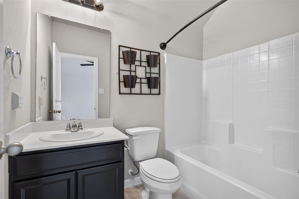 2066 Avondown Road Forney, TX 75126 - Photo 25 of 33 Bathroom featuring a dark wood vanity with a white countertop, an undermount sink, and a chrome faucet