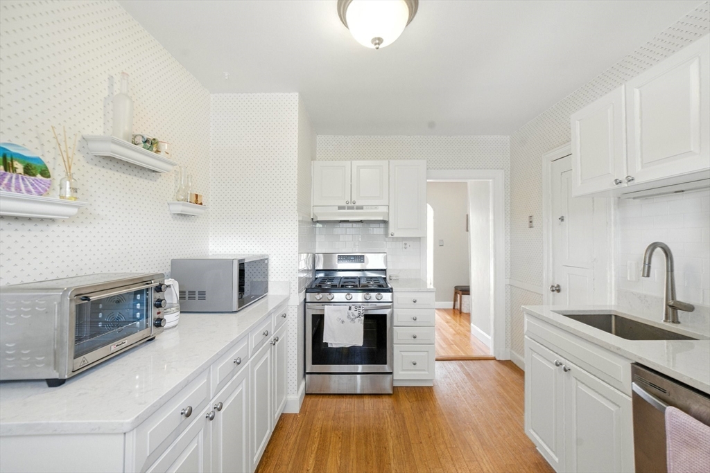 84 Strathmore Road, Unit 7 Boston, MA 02135 - Photo 8 of 17 a kitchen with stainless steel appliances a stove sink and cabinets