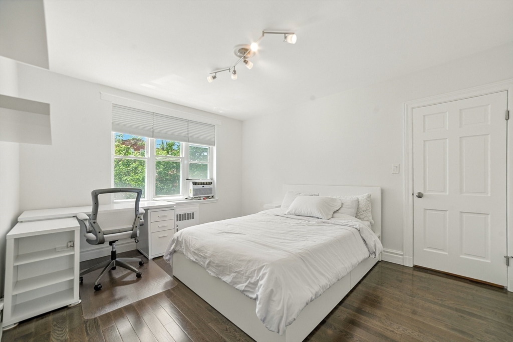 84 Strathmore Road, Unit 7 Boston, MA 02135 - Photo 9 of 17 a bedroom with a bed and a table in it
