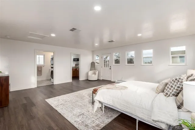 a spacious bedroom with a bed and wooden floor