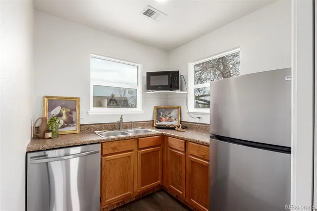 a kitchen with stainless steel appliances granite countertop a refrigerator sink stove and microwave
