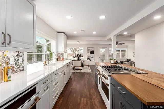a large kitchen with stainless steel appliances granite countertop a lot of counter space and wooden floors