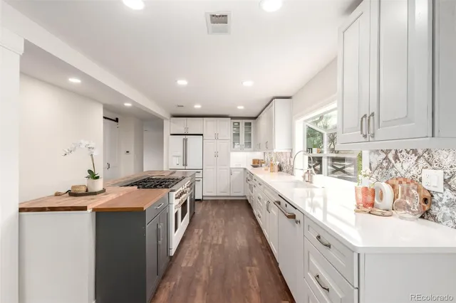 a kitchen with stainless steel appliances granite countertop a sink a stove top oven a counter space and cabinets