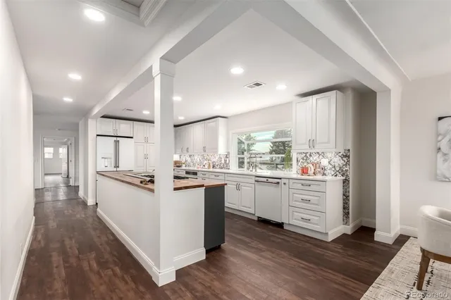 a kitchen with granite countertop white cabinets and white appliances