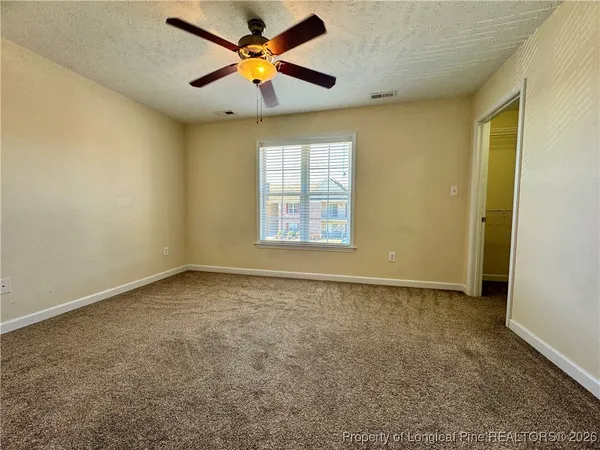 an empty room with a window and a fan