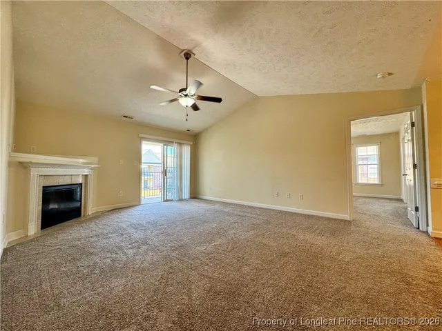 a view of an empty room with window and fireplace