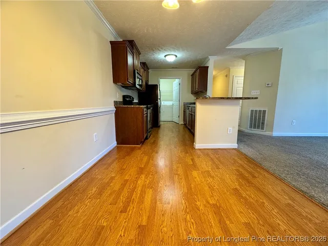 a view of kitchen with wooden floor and electronic appliances