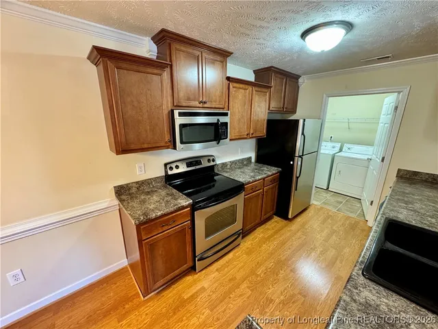 a kitchen with stainless steel appliances a stove microwave and refrigerator