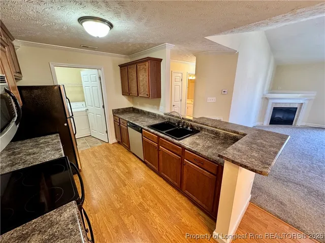 a kitchen with sink stove and refrigerator