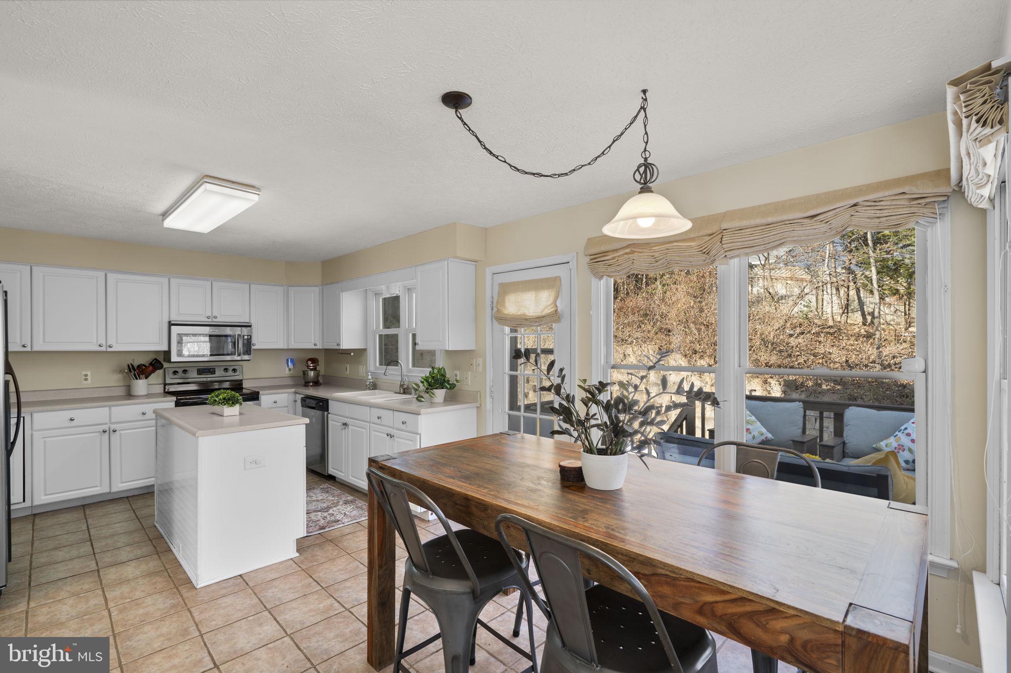 42 Lawhorn Road Stafford, VA 22554 - Photo 8 of 46 a kitchen with microwave a stove a table and chairs in it
