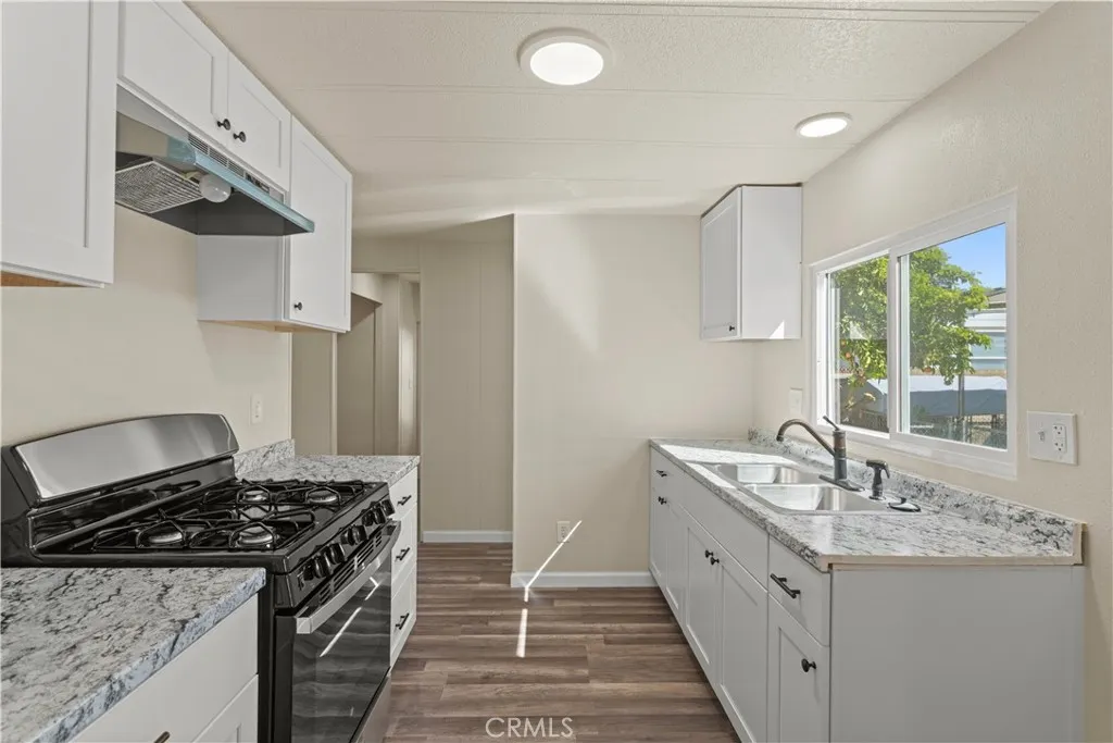 1097 North N State, Unit 194 Hemet, CA 92543 - Photo 6 of 19 a kitchen with granite countertop a sink stove and refrigerator