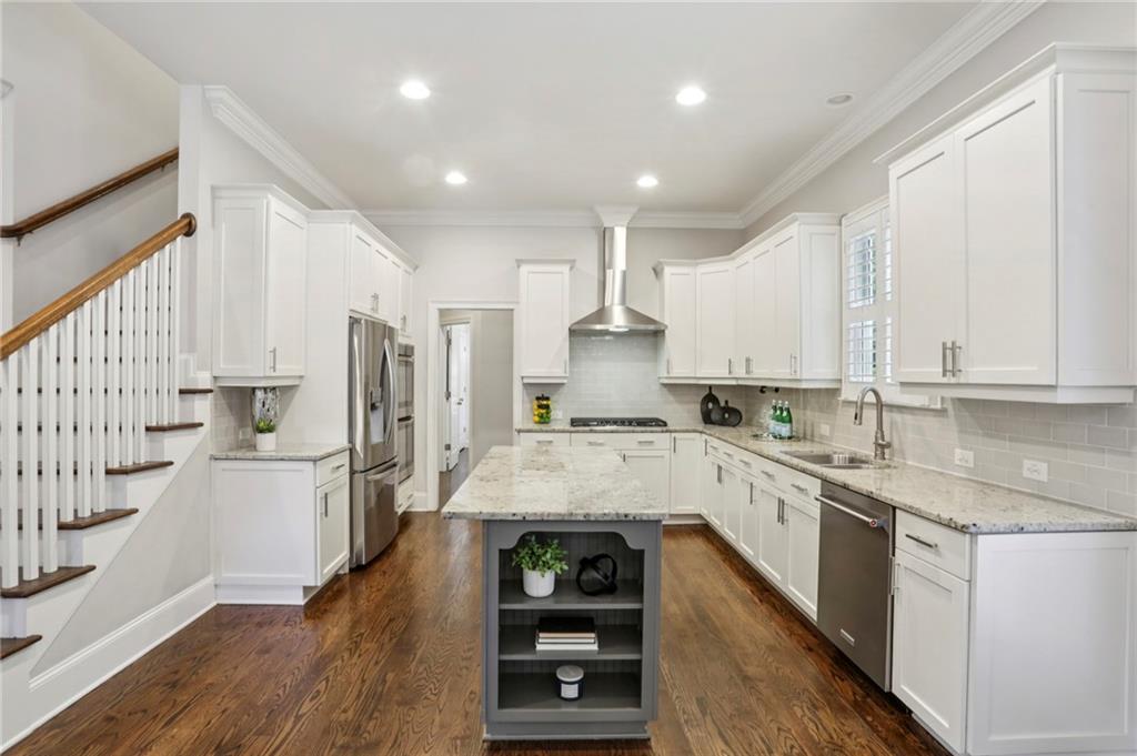 2585 Drew Valley Road Northeast Brookhaven, GA 30319 - Photo 13 of 44 a large kitchen with stainless steel appliances lots of counter space and wooden floor