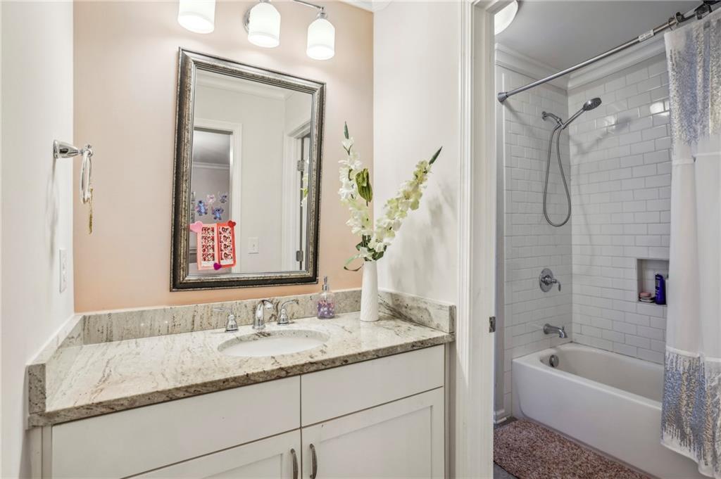 2585 Drew Valley Road Northeast Brookhaven, GA 30319 - Photo 42 of 44 a bathroom with a granite countertop tub sink and mirror