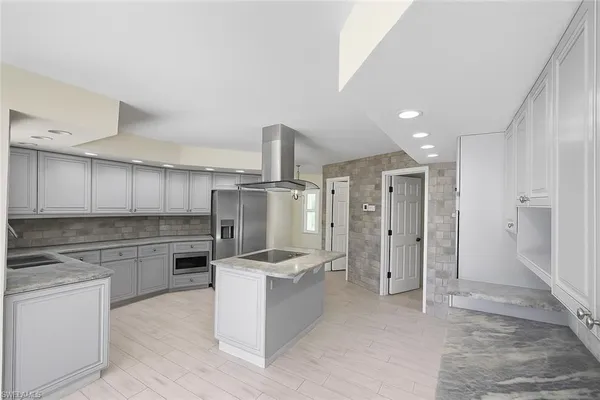 a kitchen with stainless steel appliances granite countertop a refrigerator and a stove
