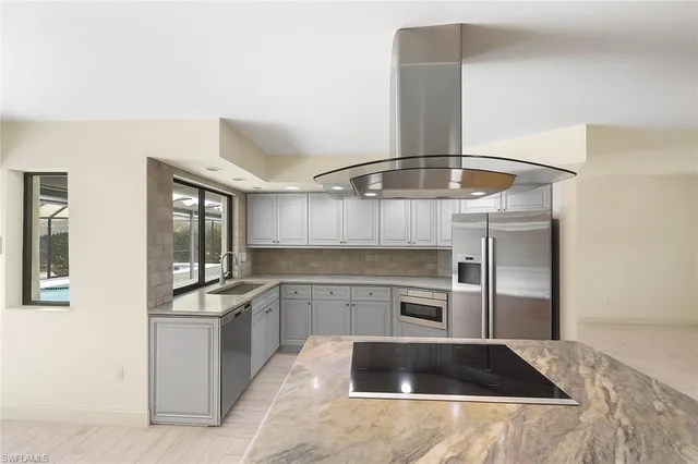 a kitchen with stainless steel appliances a stove refrigerator and cabinets