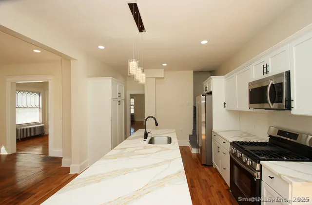 a kitchen with stainless steel appliances kitchen island sink refrigerator stove and microwave