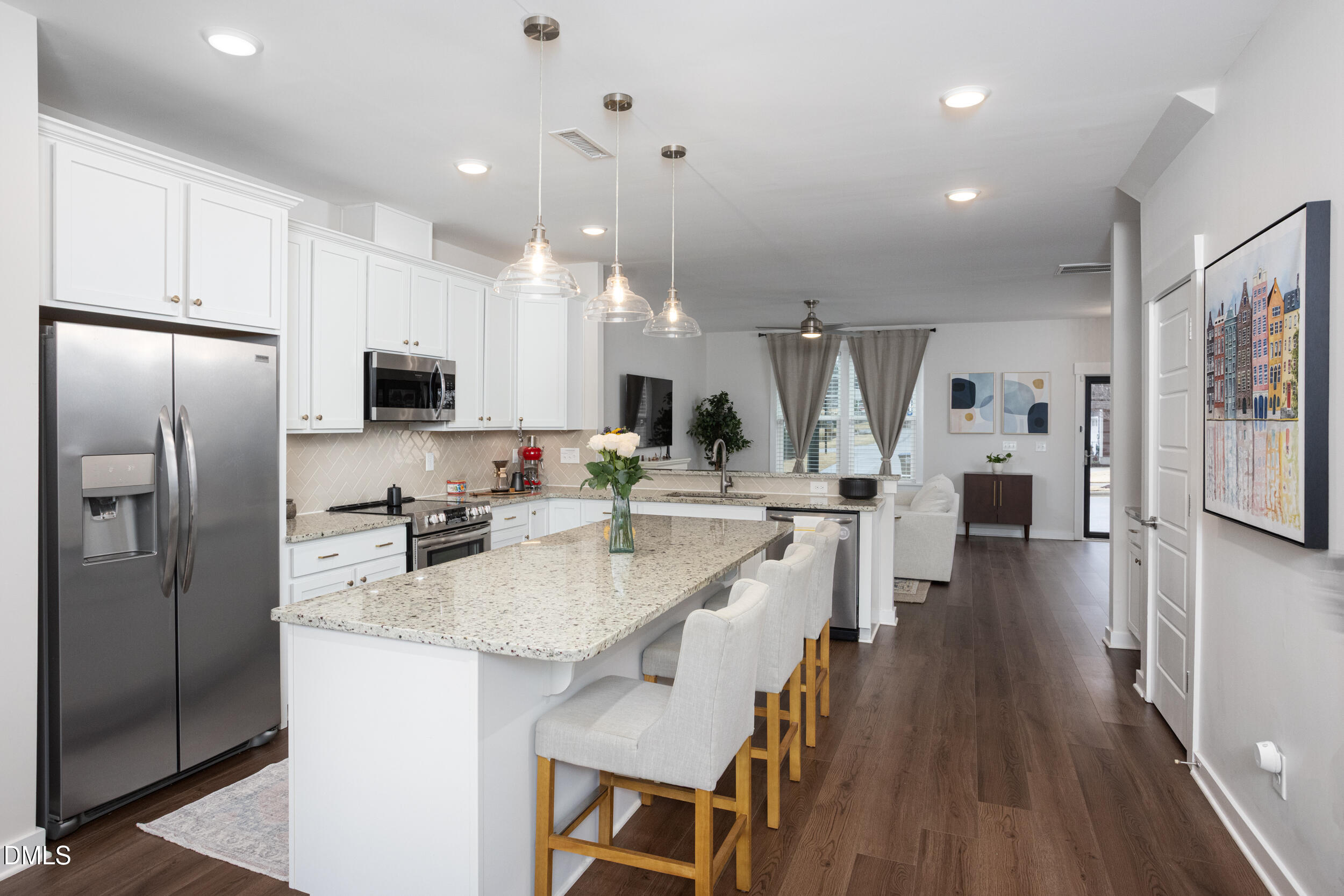 469 Rally Point Place Wake Forest, NC 27587 - Photo 7 of 37 a kitchen with stainless steel appliances granite countertop a refrigerator a stove top oven a sink dishwasher and white cabinets with wooden floor