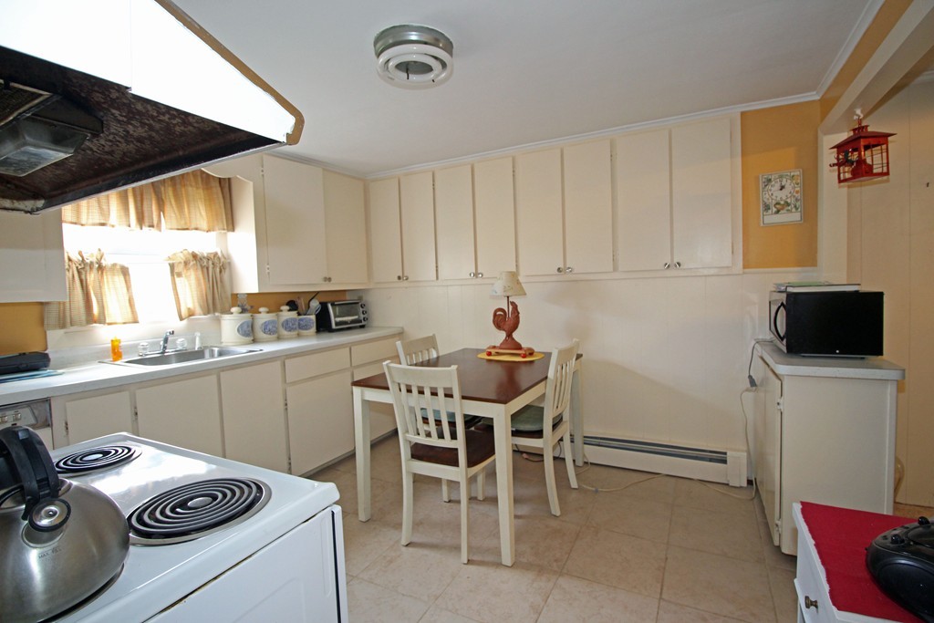 430 Newport Road Hull, MA 02045 - Photo 3 of 10 a kitchen with a sink a stove and chairs
