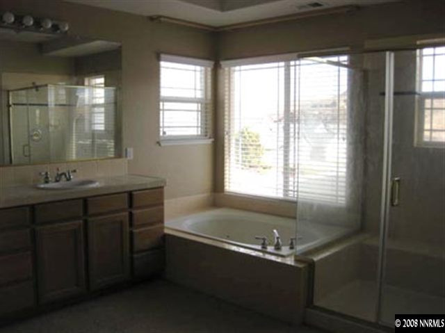 4542 Goodwin Road Sparks, NV 89436 - Photo 8 of 9 a bathroom with a tub sink and mirror