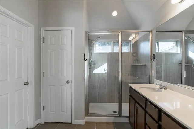a bathroom with a double vanity sink mirror and shower