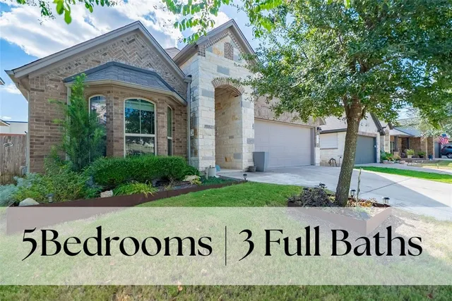 a view of front of house with a street sign and a large tree