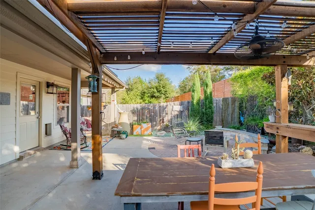 a view of a chair and table in backyard of the house