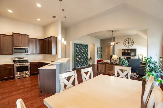 a large kitchen with sink a counter top space appliances and cabinets