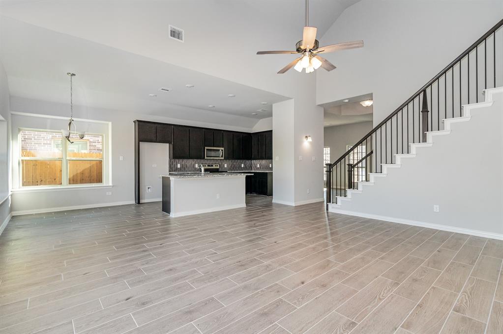 232 Cisco Trail Forney, TX 75126 - Photo 7 of 27 a view of a kitchen with a stove cabinets a ceiling fan and wooden floor